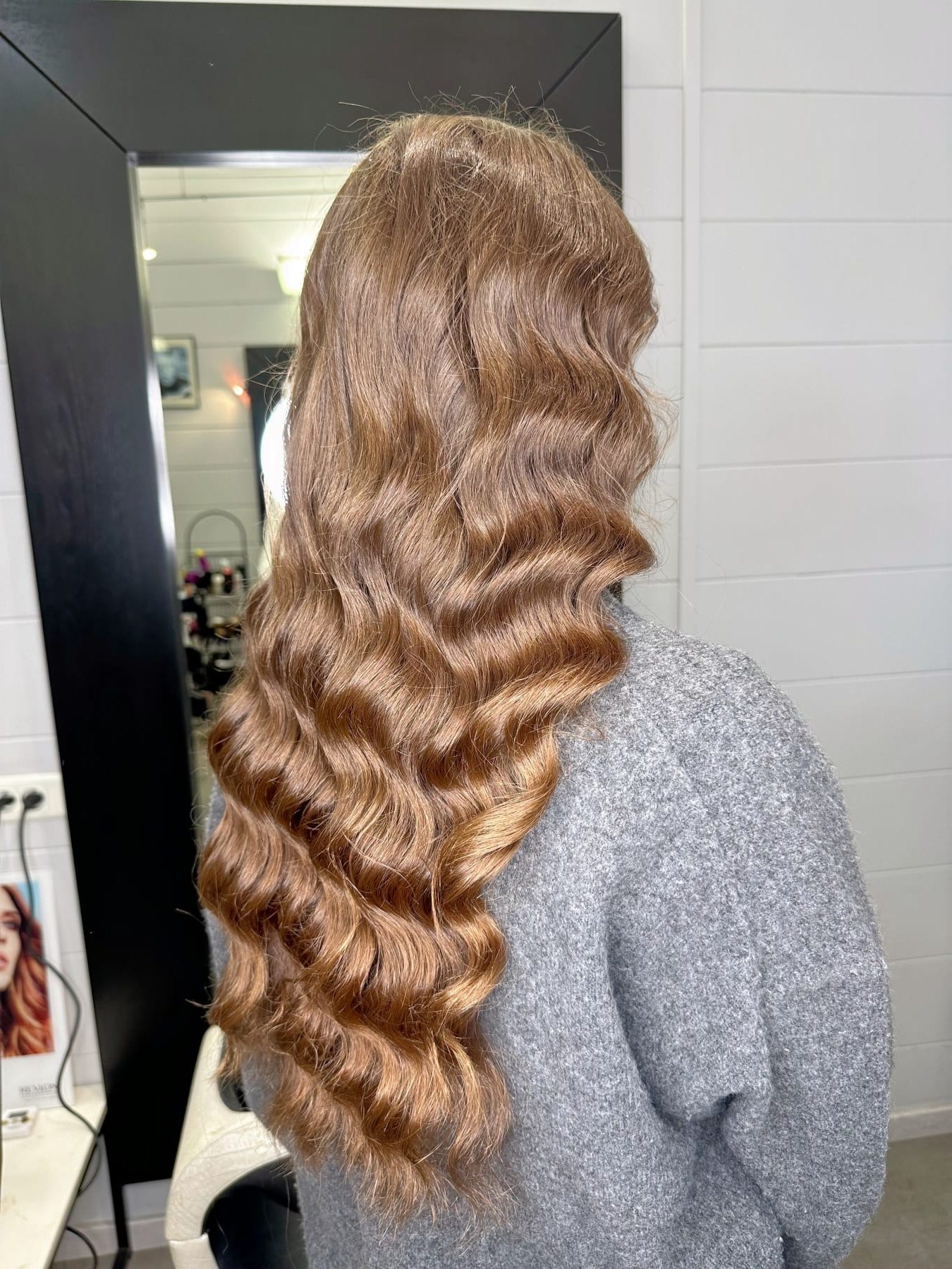 Chevelure châtain doré aux ondulations marquées, réalisée au salon